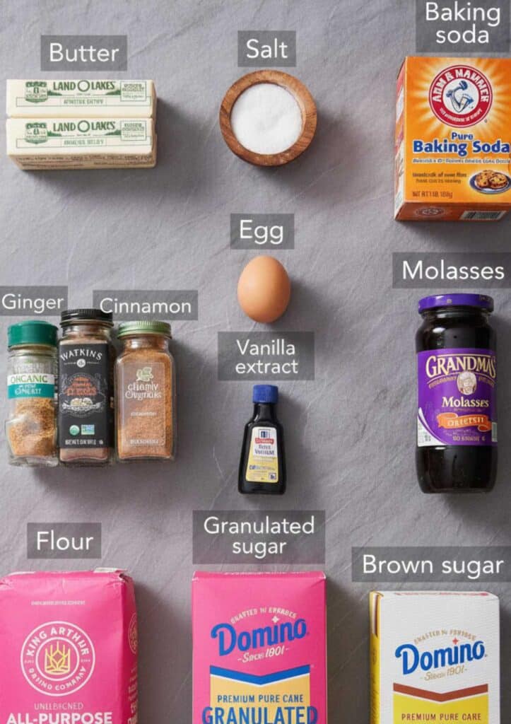 Flat lay of gingersnap cookie ingredients including flour, brown sugar, butter, molasses, spices, and vanilla extract