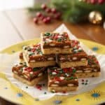 Christmas Crack with chocolate and pecans on a yellow plate