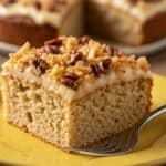 Close-up of Do Nothing Cake slice on yellow plate with coconut and pecans