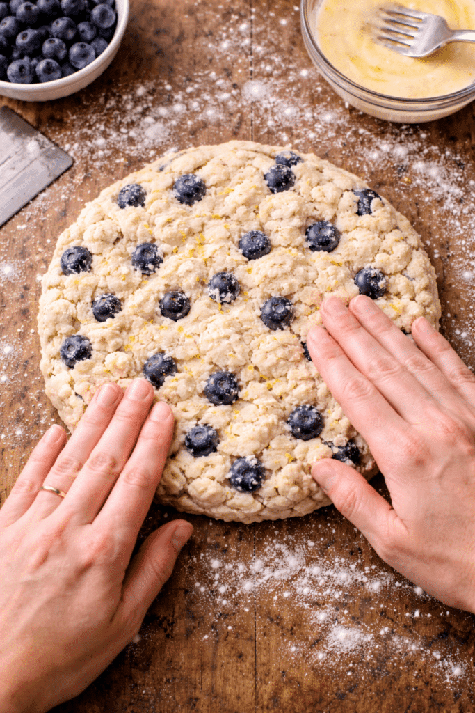 Shaping blueberry scone dough into a round disk
