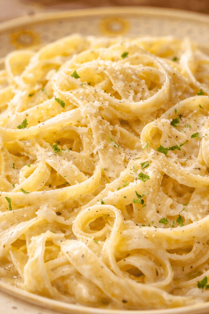 Close-up of creamy Fettuccine Alfredo sauce coating pasta